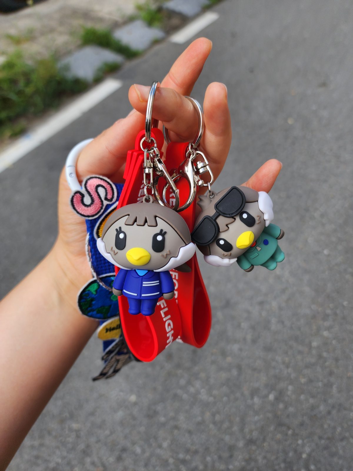 Hoki and Poki silicone keyrings held in hand