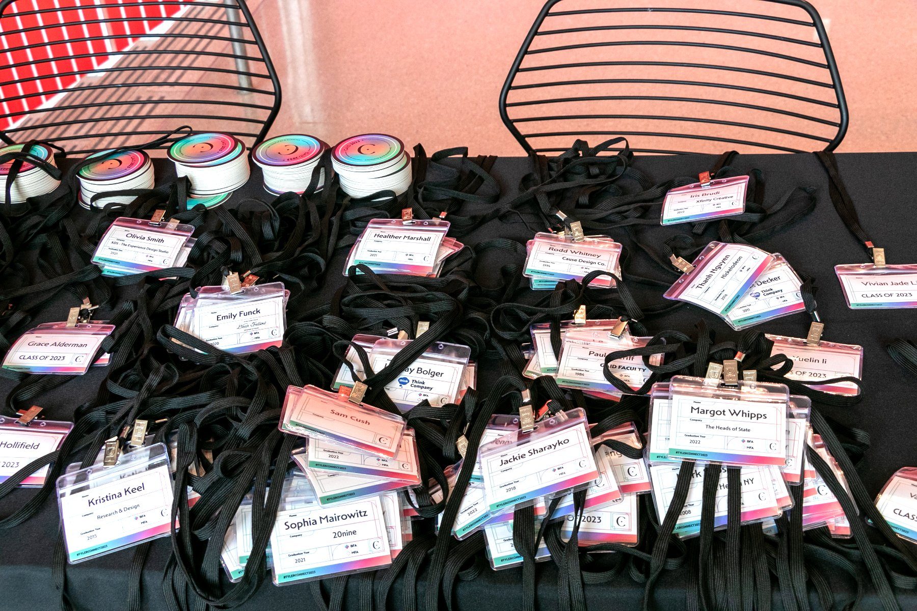 Assembled name tags with lanyards and stacked coasters on the check-in table